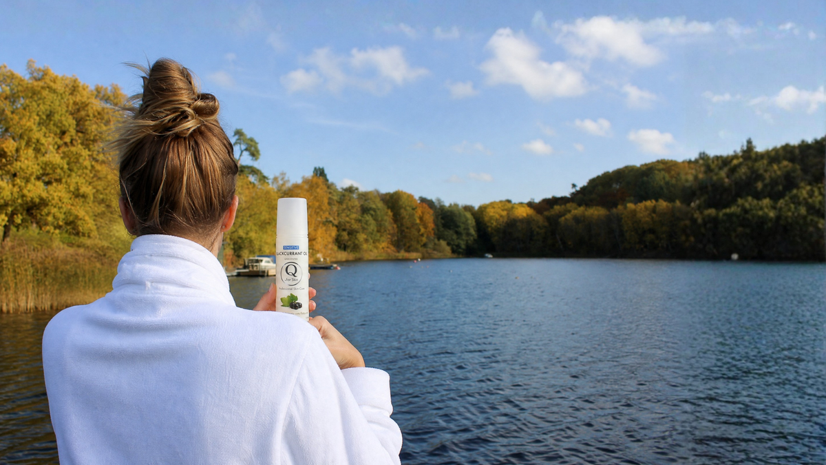 Kvinna på brygga vid sjö med Q for Skin-produkter